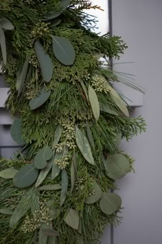 a green wreath hanging from the side of a door