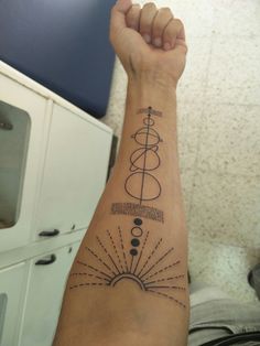 a person with a tattoo on their arm holding up a peace sign and sunburst