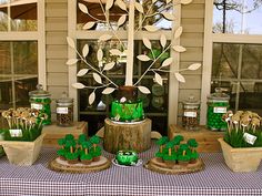 a table topped with green cake and cupcakes