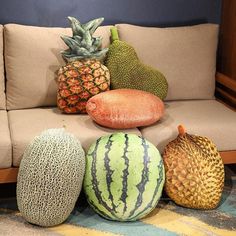 various types of fruit sitting on top of each other in front of a beige couch