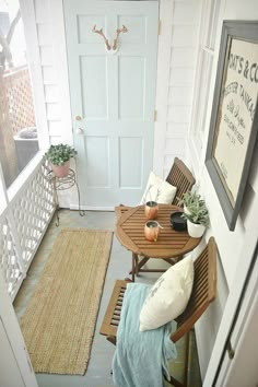 an entryway with two wooden chairs and a table on the floor next to a door