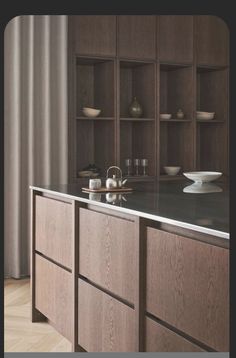 a kitchen with wooden cabinets and black granite counter tops, along with white dishes on shelves