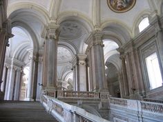 an old building with many pillars and arches on the ceiling, along with a clock