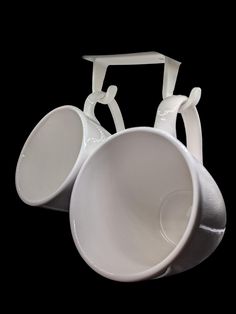 three white bowls are stacked on top of each other in the shape of an oar