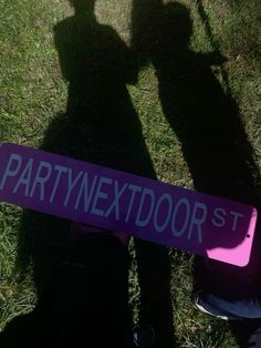 a person holding a purple sign that says partynextdoor st in front of their shadow