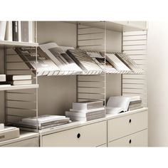 the shelves are filled with files and folders in this office space, all white