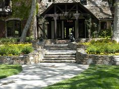 a house with stone steps leading up to the front door and entry way, surrounded by lush green grass