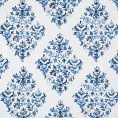 a blue and white fabric with an ornate design on it's back ground, next to a ruler