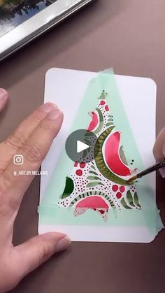 someone is painting a watermelon christmas tree card with sharpie markers on it