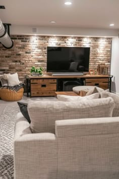 a living room filled with furniture and a flat screen tv mounted on the wall above it