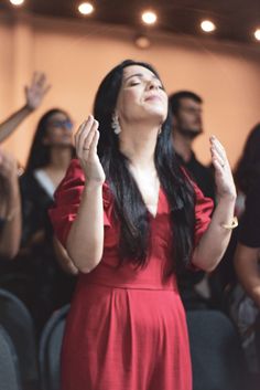 a woman in a red dress is clapping