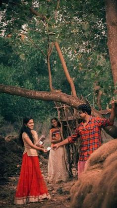 two women and a man standing in the woods