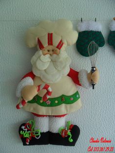 a santa clause is hanging on the wall next to other christmas decorations and kitchen utensils