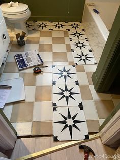 a bathroom floor that has been painted with black and white stars on it, next to a toilet