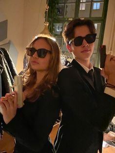 two people standing next to each other wearing sunglasses