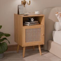 a bedside table with a radio on it and a plant in the corner next to it