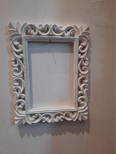 an ornate white frame hanging on the wall