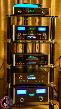 a stack of stereo equipment sitting on top of a wooden floor next to a wall