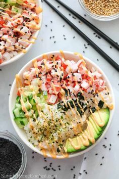 two bowls filled with different types of food next to chopsticks and seasoning