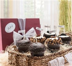 chocolate cupcakes are sitting in a wicker basket with ribbons and tags on them