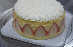 a cake with white frosting and strawberries on top sitting on a platter