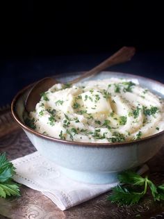 a bowl filled with mashed potatoes and parsley