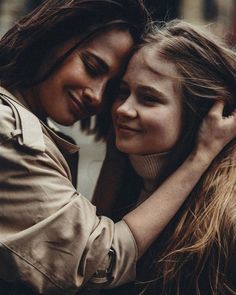 two young women hugging each other on the street