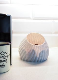 a coffee cup sitting next to a ceramic vase