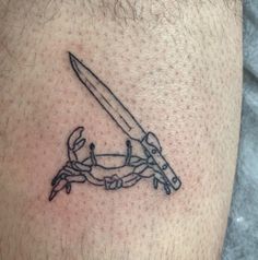 a tattoo on the leg of a man with a knife and chain attached to it