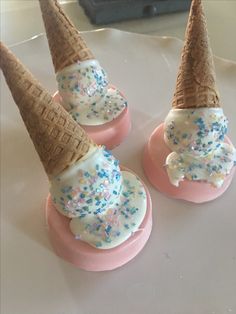 three ice cream cones with sprinkles on them sitting on top of each other