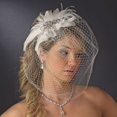 a woman wearing a bridal veil with feathers on it's head and necklace