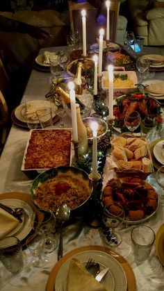 a dinner table is set with candles and food