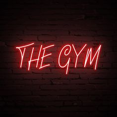 the gym neon sign on a brick wall