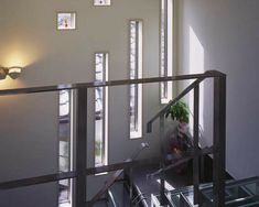 an indoor stair case with glass railing and metal handrails