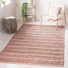 a pink and brown striped rug in a white room with a chair, potted plant and window