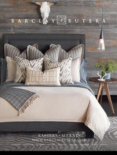 a bedroom with zebra print rugs and pillows on the bed in front of a wood paneled wall