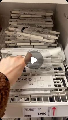 a person is reaching for some kind of item in a drawer that's filled with files