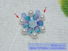 the beading is being worked on with pearls and beads, as well as an arrow