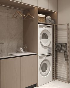 a washer and dryer in a small laundry room with cabinets on either side