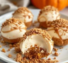 some desserts are on a white plate with pumpkins in the backgroud