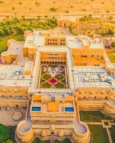 an aerial view of a large building in the middle of a field with lots of trees