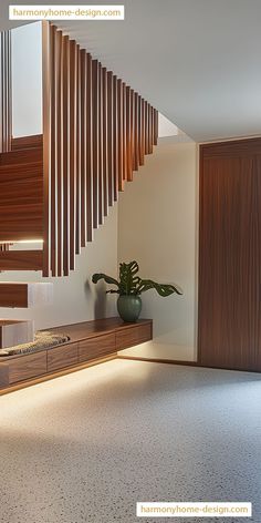 a wooden stair case next to a potted plant on top of a table in a room