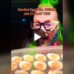 a woman with green hair and glasses making funny faces in front of an assortment of deviled eggs