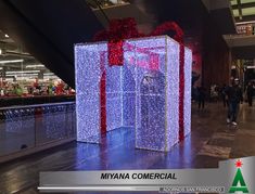 a large display in the middle of an airport with lights on it and people walking around