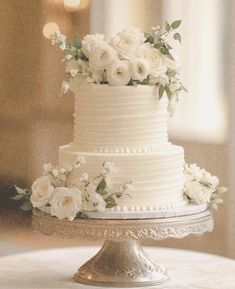 a white wedding cake with flowers on top