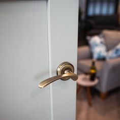 an open door with a handle on it in front of a living room chair and coffee table