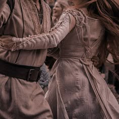 two people dressed in historical clothing dancing together