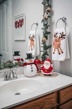 a bathroom decorated for christmas with santa and reindeer towels