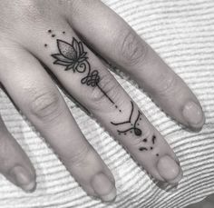 a woman's hand with a small tattoo on the middle finger and an arrow