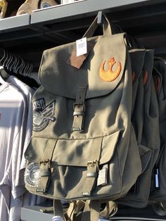 a star wars backpack hanging on a rack in a store with other items behind it